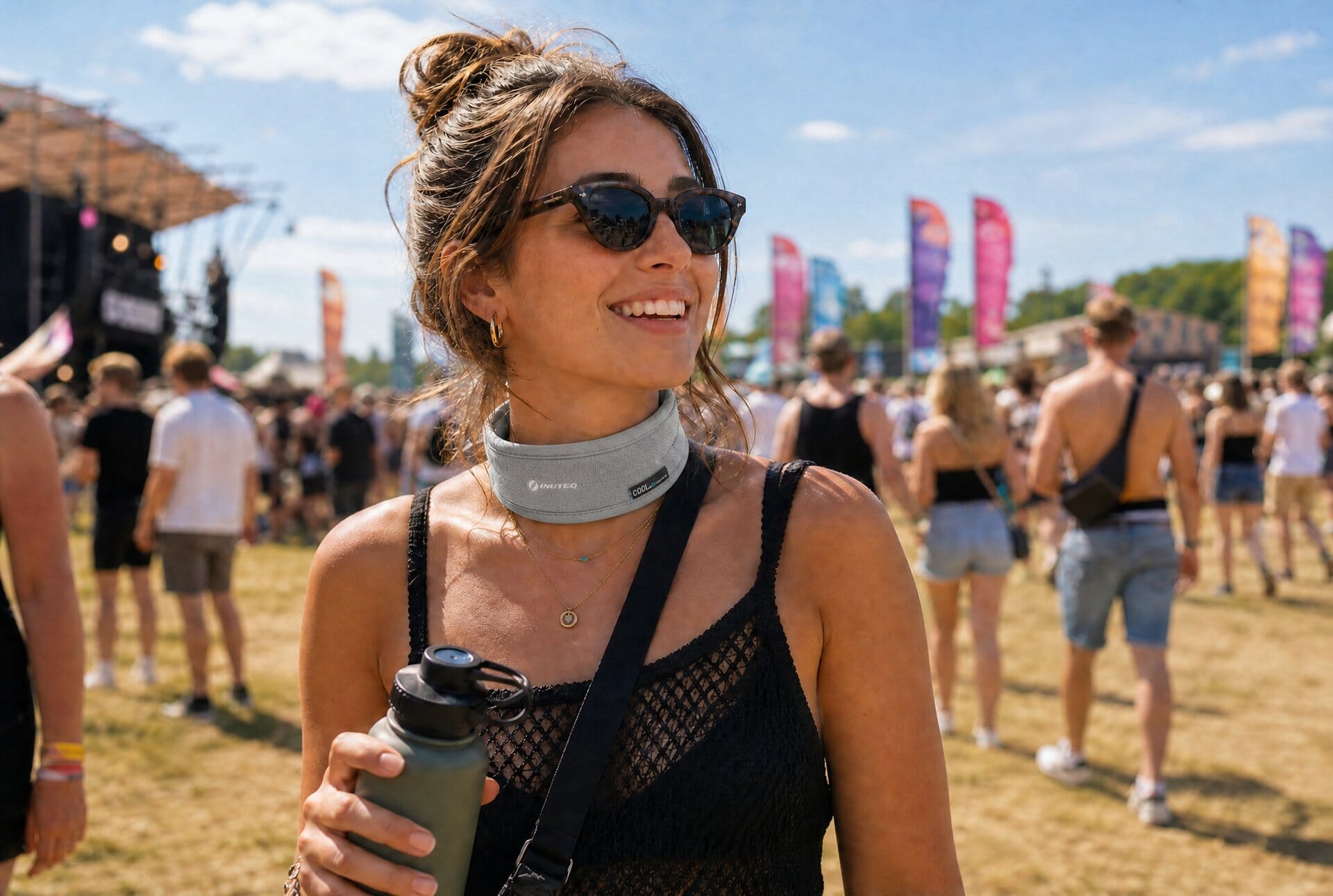 Bezoeker met verkoelende nekkoeler op een zomers festivalterrein